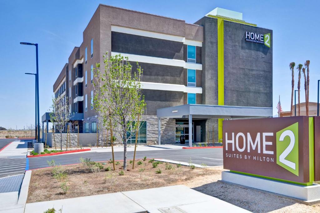 un edificio con una señal de casa delante de él en Home2 Suites By Hilton Palmdale en Palmdale