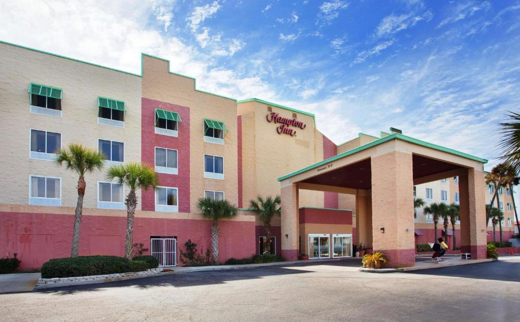 a hotel building with palm trees in front of it at Hampton Inn Pensacola Beach in Pensacola Beach