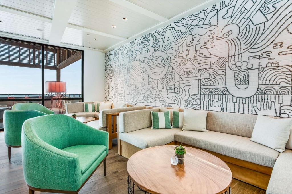a living room with a large mural on the wall at The Lodge at Gulf State Park, A Hilton Hotel in Gulf Shores
