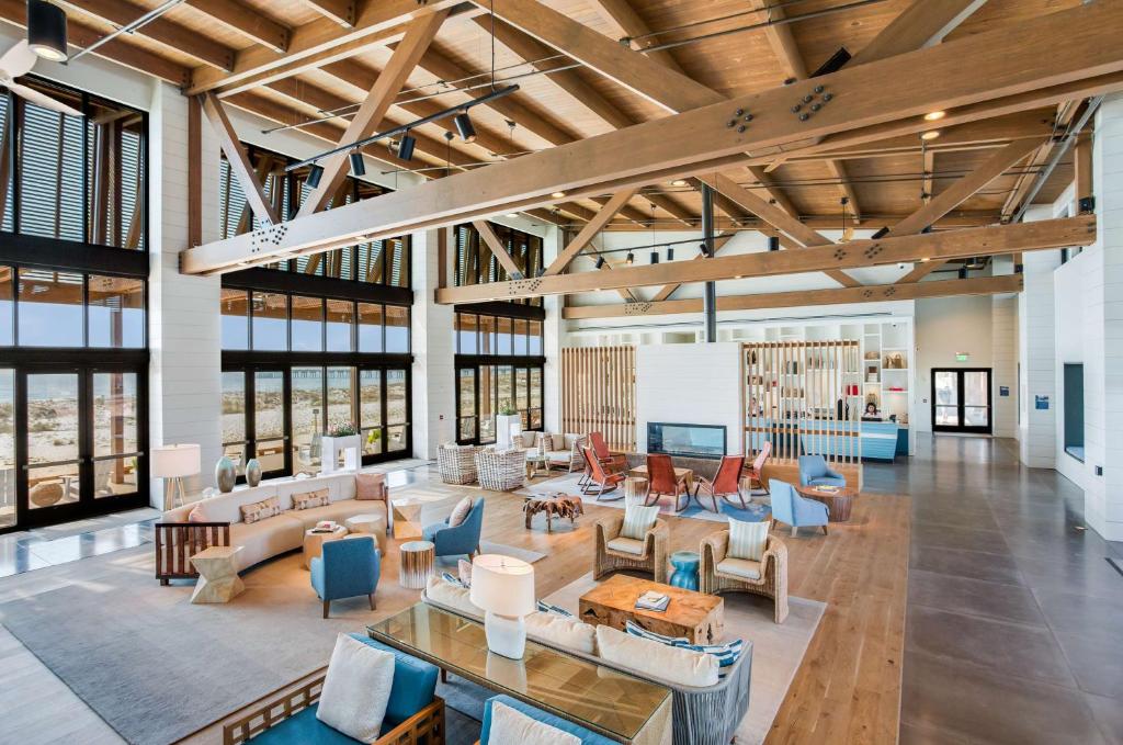 eine große Lobby mit vielen Möbeln und Fenstern in der Unterkunft The Lodge at Gulf State Park, A Hilton Hotel in Gulf Shores