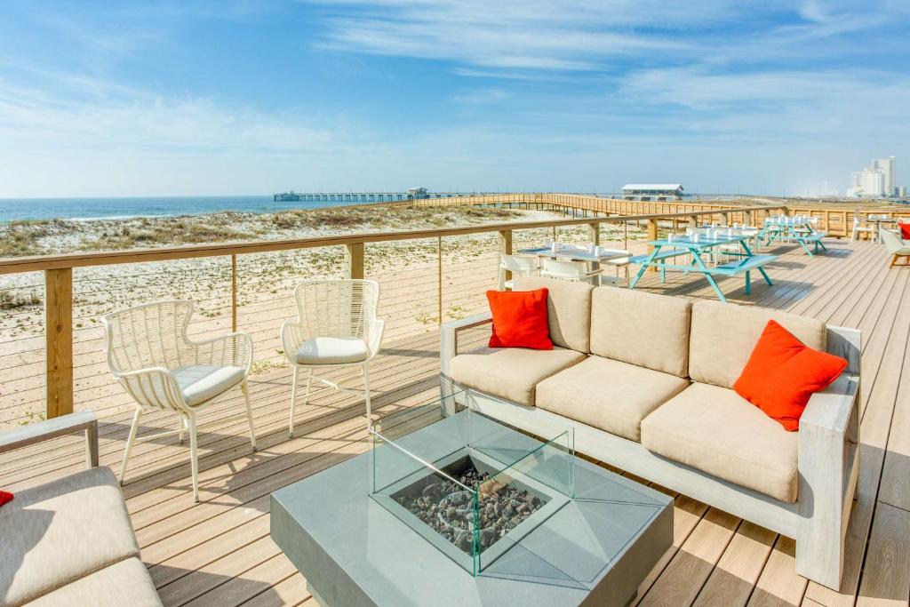 a living room with a couch and chairs and the beach at The Lodge at Gulf State Park, A Hilton Hotel in Gulf Shores