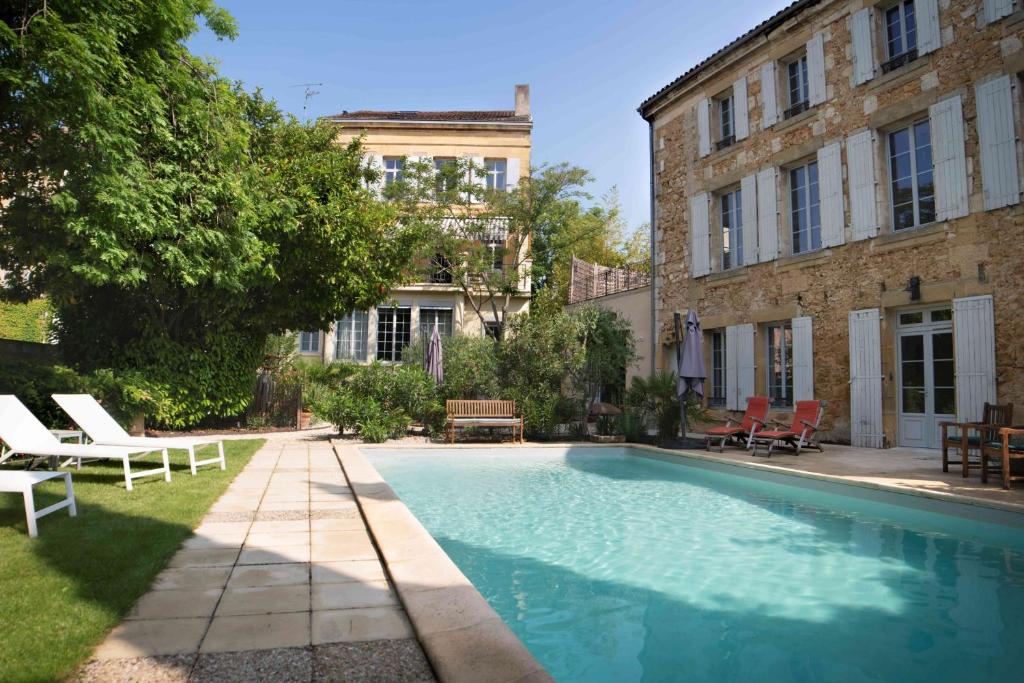a swimming pool in a yard next to a building at Maison Argenson in Bergerac