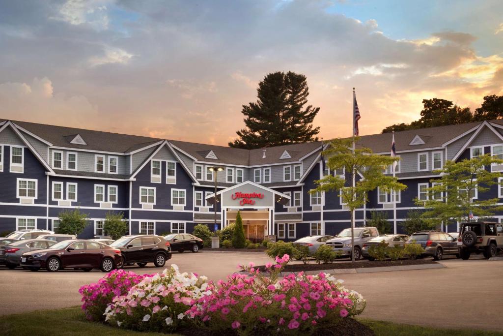 a large blue building with cars parked in a parking lot at Hampton Inn Dover in Dover