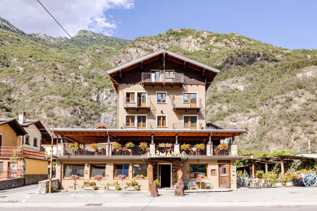 a building in front of a mountain at Hotel&Restaurant Armanac de Toubïe in Arnad