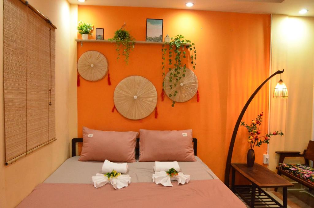Un dormitorio con paredes de color naranja y una cama con flores. en Northern Hostel - Bui Vien Walking Street, en Ho Chi Minh