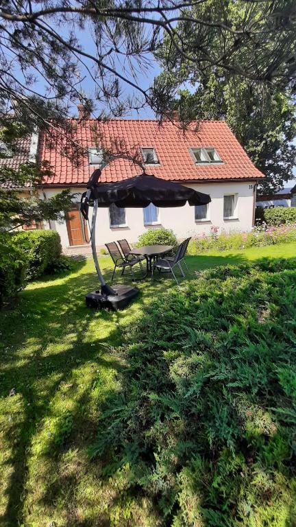 a picnic table and bench in the yard of a house at Apartament Pod Dębem in Żarnowska