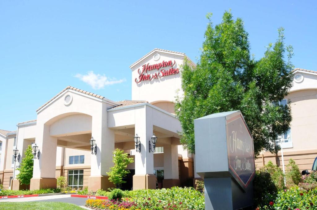 a hotel building with a clock in front of it at Hampton Inn & Suites Redding in Redding