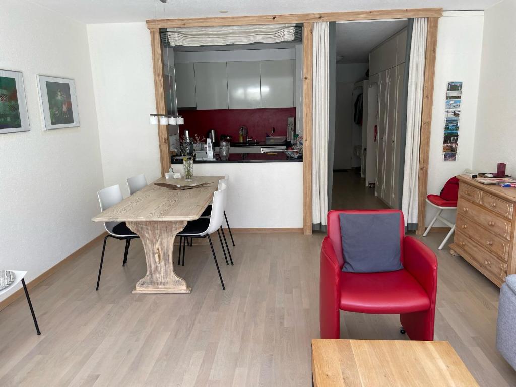 Il comprend un salon avec une table et des chaises ainsi qu'une cuisine. dans l'établissement Tulai D74, à Scuol