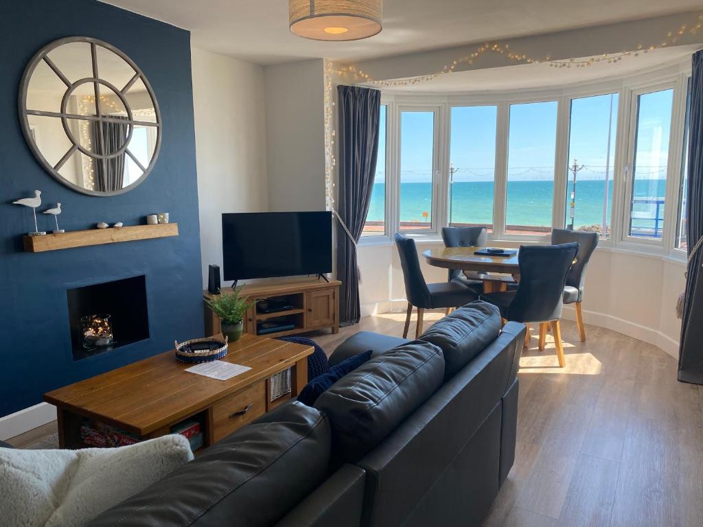 a living room with a couch and a television and a table at WORTHING BEACH 180 - 2 bed seafront apartment with private parking in Worthing