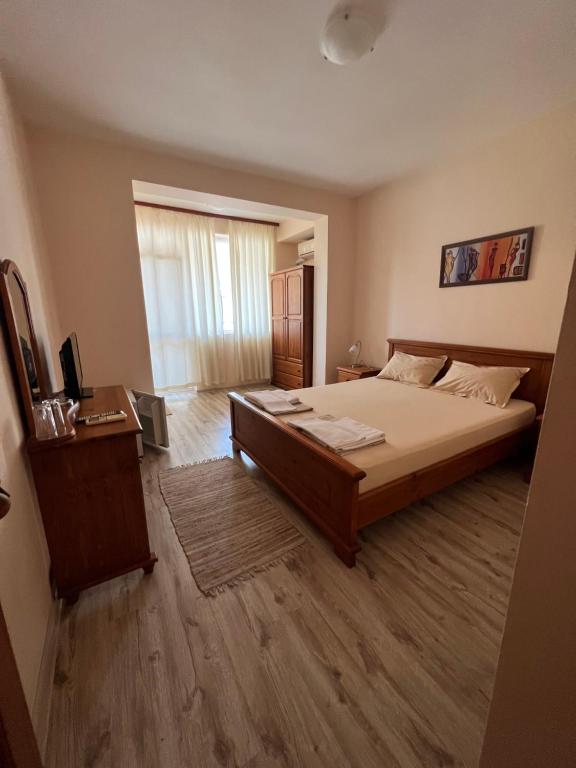 een slaapkamer met een bed en een televisie. bij Семеен хотел Авалон in Chernomorets