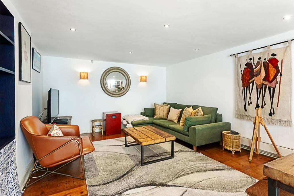 a living room with a couch and a table at Cottage Style Three Bedroom House in London