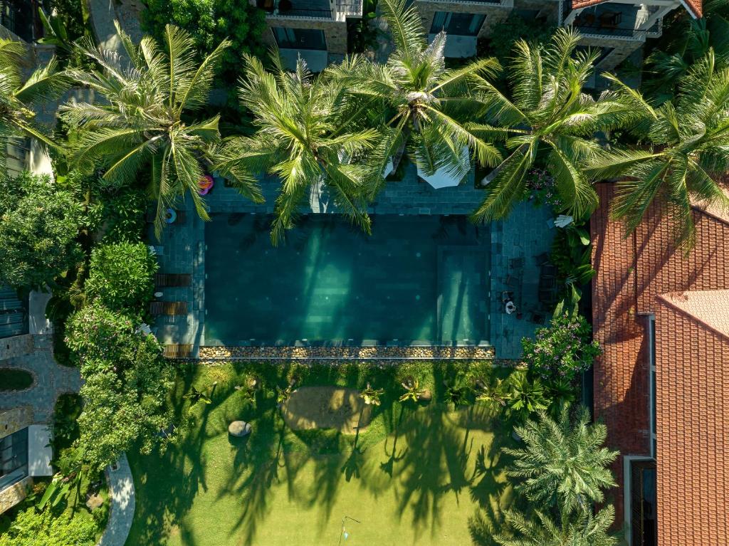 eine Draufsicht auf einen Swimmingpool mit Palmen in der Unterkunft Coco Island Resort Ninh Binh in Ninh Bình