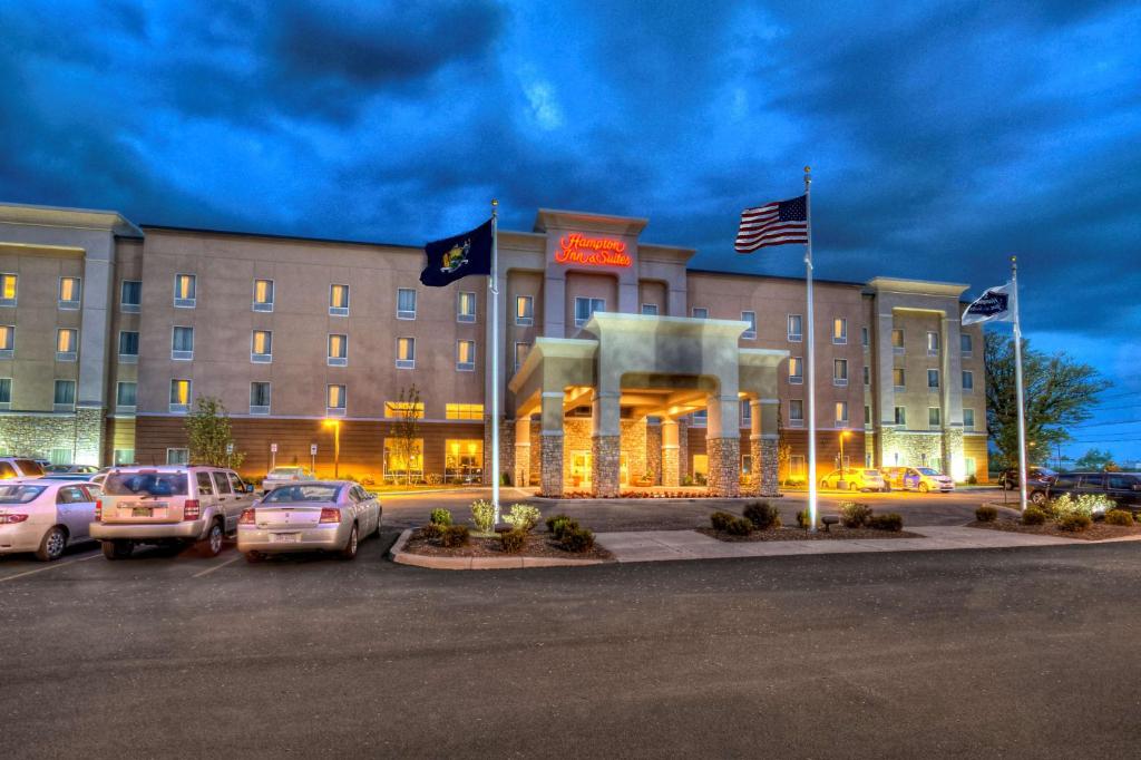 a hotel with cars parked in a parking lot at Hampton Inn & Suites Rochester/Henrietta in Rochester