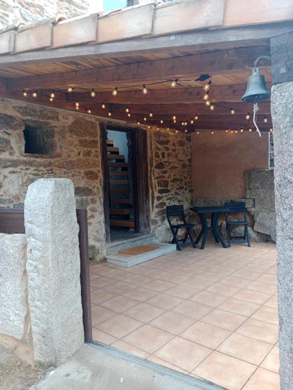 Un patio con una mesa y luces. en La Gavina, en Beáriz