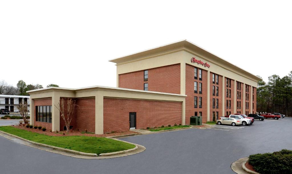 a building with a car parked in a parking lot at Hampton Inn Roxboro in Roxboro