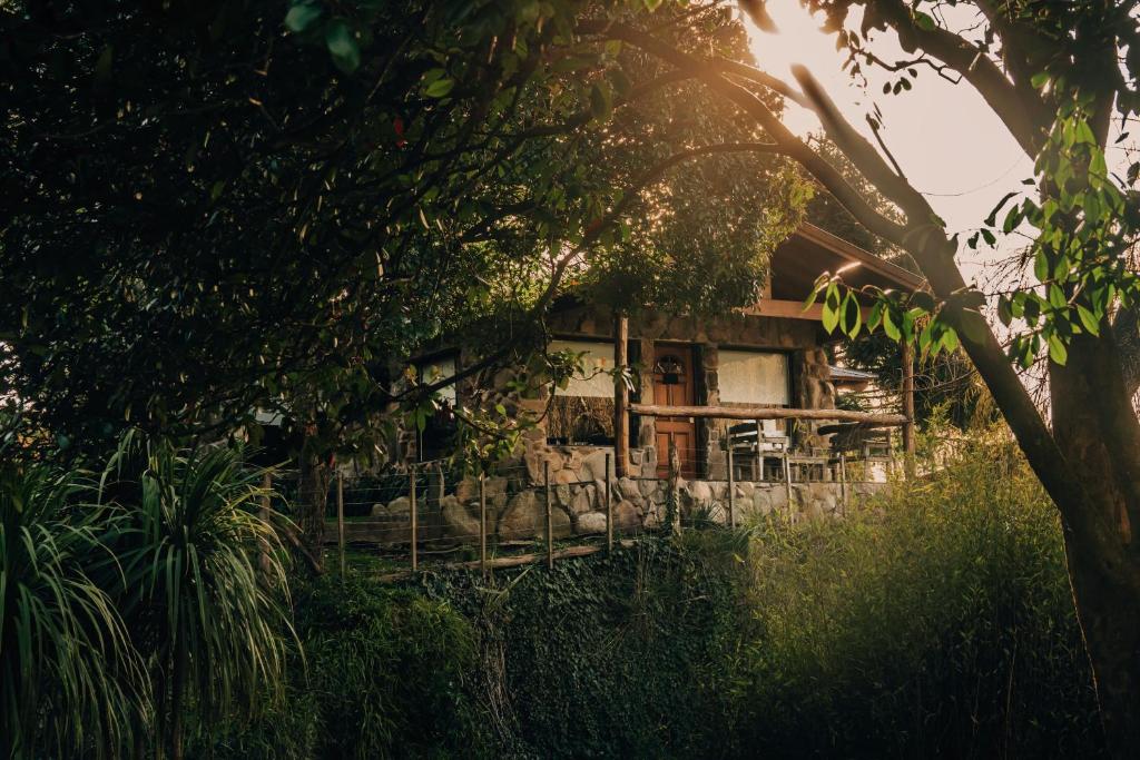 una casa vieja en medio de un bosque en Hostería & Spa De La Cascada en Tandil