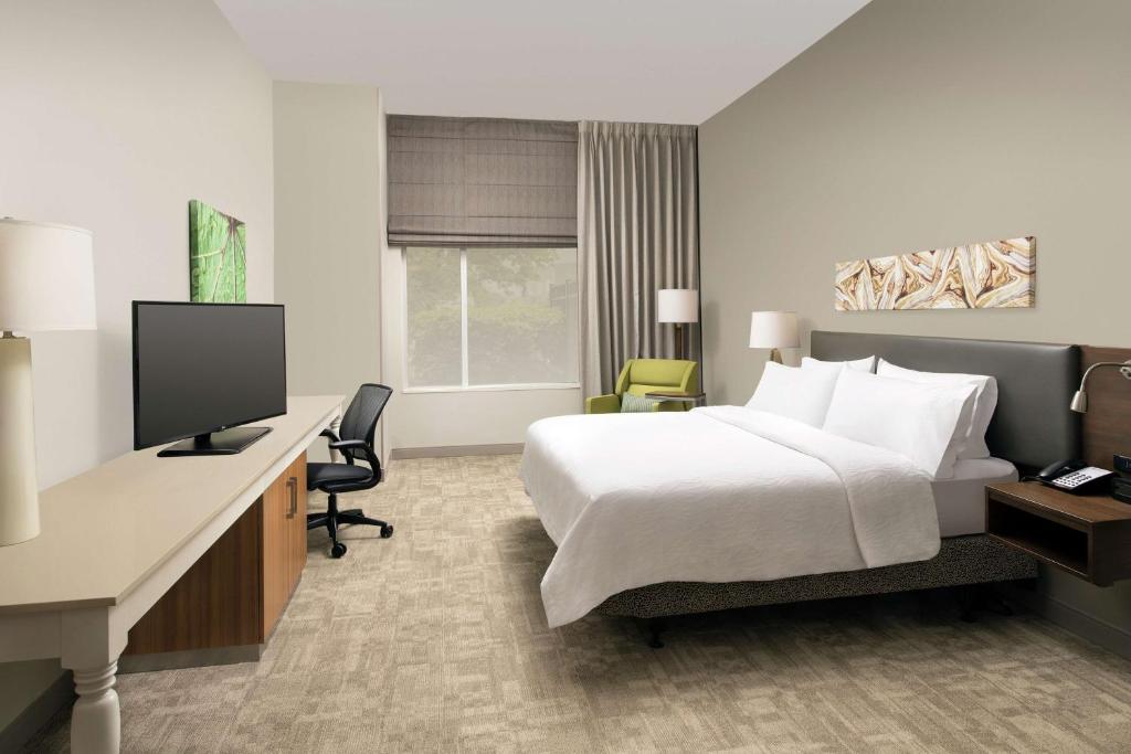 a hotel room with a bed and a desk and a tv at Hilton Garden Inn San Antonio Airport South in San Antonio