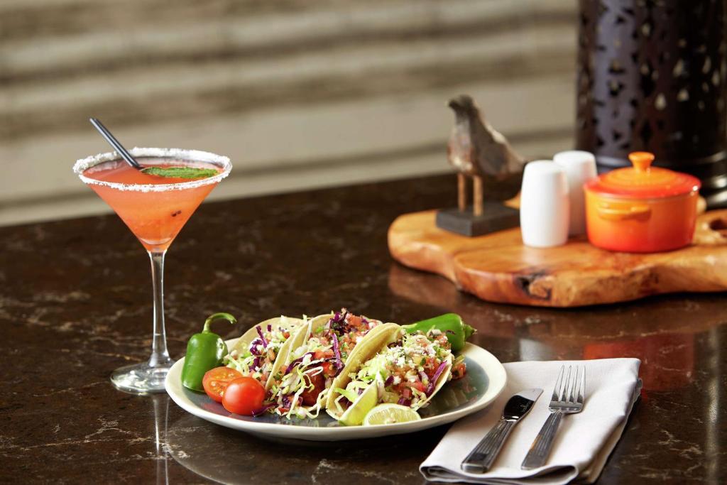 a table with a plate of food and a drink at Hilton Garden Inn San Diego Mission Valley/Stadium in San Diego