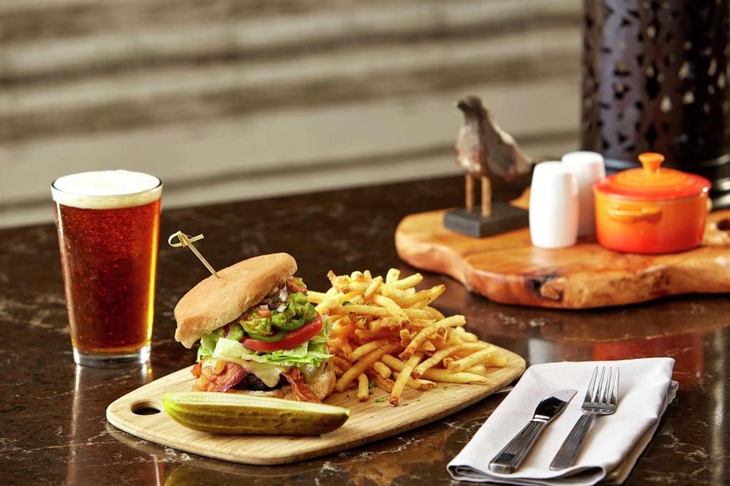 a sandwich and french fries on a table with a drink at Hilton Garden Inn San Diego Mission Valley/Stadium in San Diego