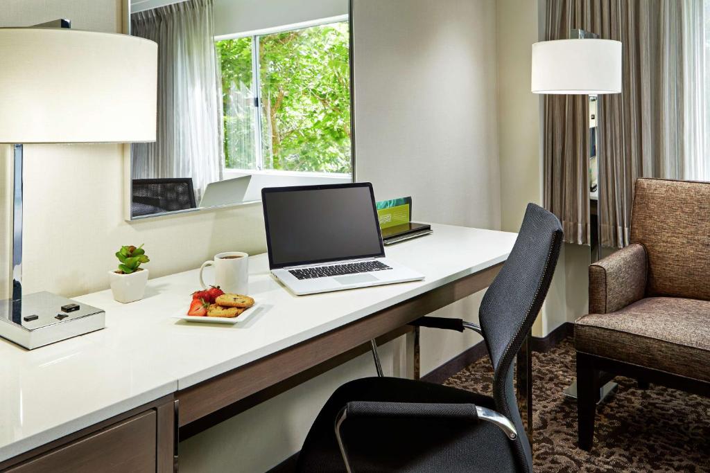 a room with a desk with a laptop and a chair at Hilton Garden Inn San Diego Mission Valley/Stadium in San Diego