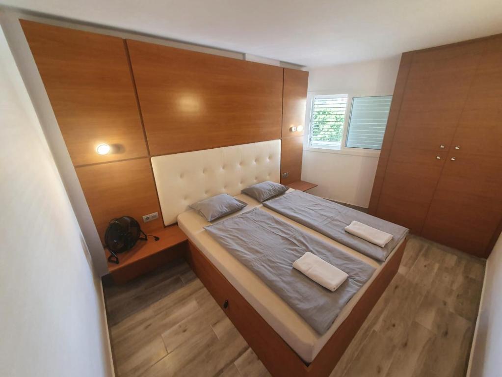 a bedroom with a large bed with wooden cabinets at Hideaway Tenerife Holiday Apartment Las Américas in Playa Fañabe