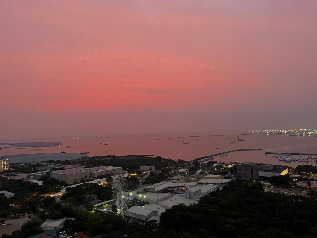 uma vista para uma cidade à noite com um céu rosa em Penthouse at the Coast with Prime and DisneyPlus em Manila