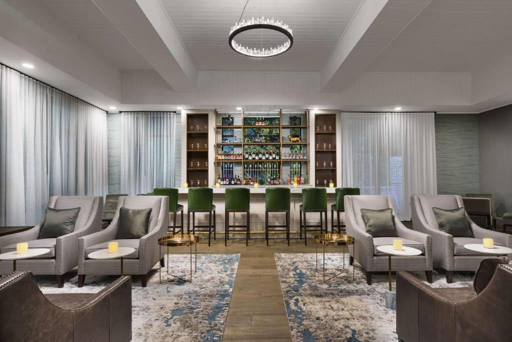 uma sala de espera com cadeiras e um bar em The Bluff Hotel Savannah, Tapestry Collection by Hilton em Savannah