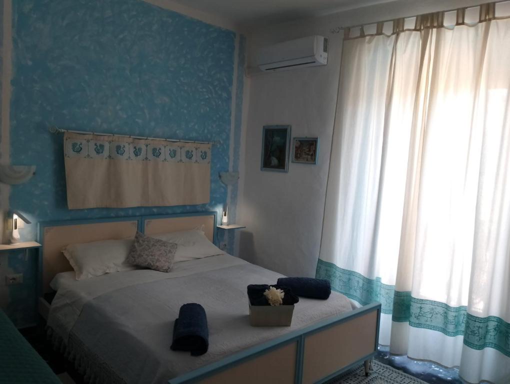 a bedroom with a bed with a blue wall at B&b Ammentos in Magomadas