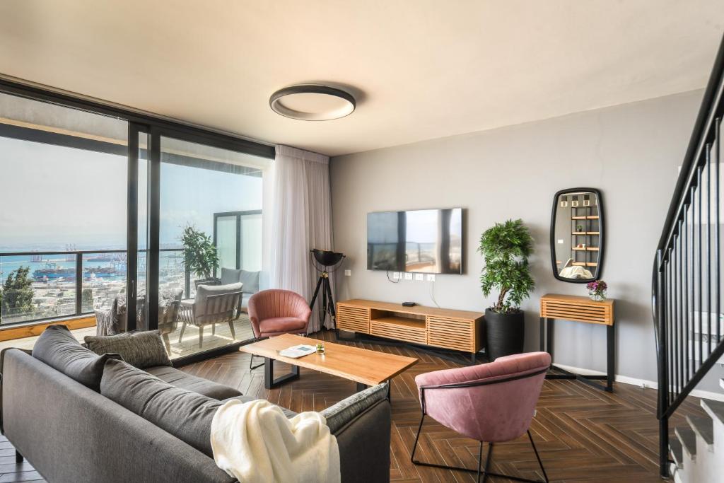 un soggiorno con divano e tavolo di Stunning 2BR Apartment with Balcony and Ocean View in the Heart of Haifa by Sea N' Rent a Haifa