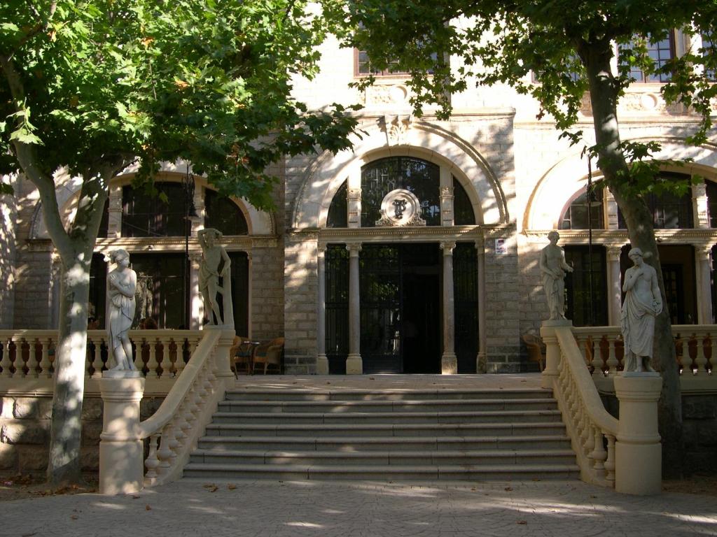 un edificio con escaleras y estatuas delante en Hotel Parque Balneario Termas Pallares, en Alhama de Aragón