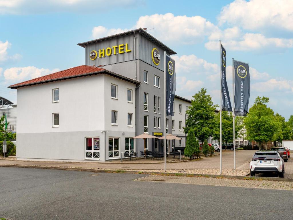 ein großes weißes Gebäude mit Hotelschild drauf in der Unterkunft B&B Hotel Hannover-Lahe in Hannover