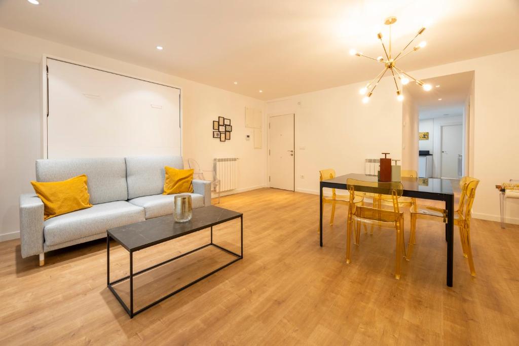 a living room with a couch and a table at Apartamentos Ábaster Suites in Soria