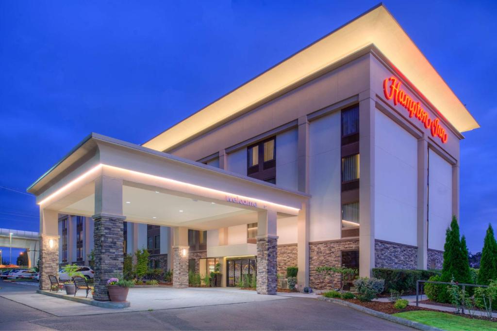 un hotel con un cartel en la parte delantera en Hampton Inn Seattle Airport, en SeaTac