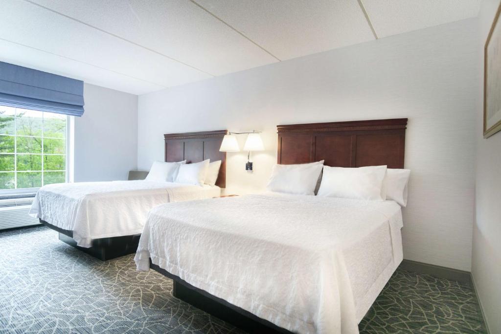 a hotel room with two beds and a window at Hampton Inn & Suites Berkshires-Lenox in Lenox