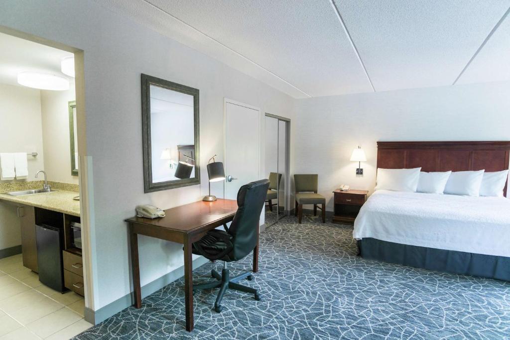 a hotel room with a bed and a desk and a bedroom at Hampton Inn & Suites Berkshires-Lenox in Lenox
