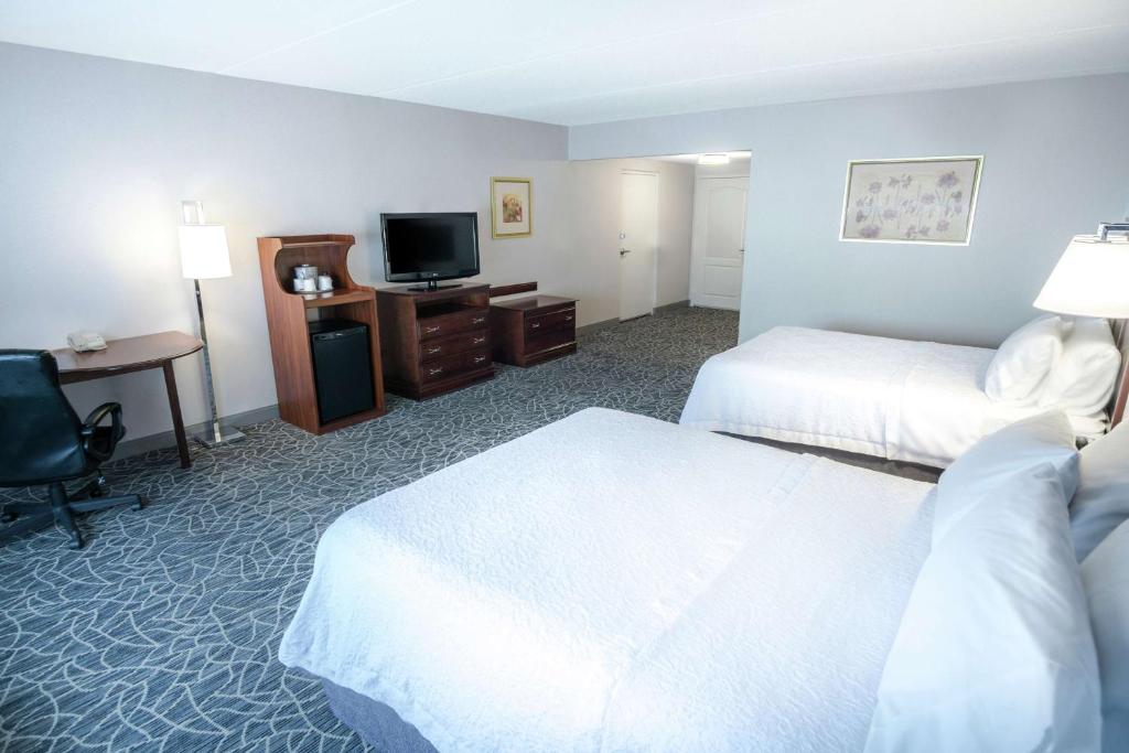 a hotel room with two beds and a desk and a television at Hampton Inn & Suites Berkshires-Lenox in Lenox