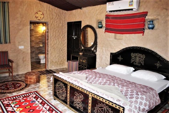 Un pat sau paturi într-o cameră la Al Reem Desert Camp