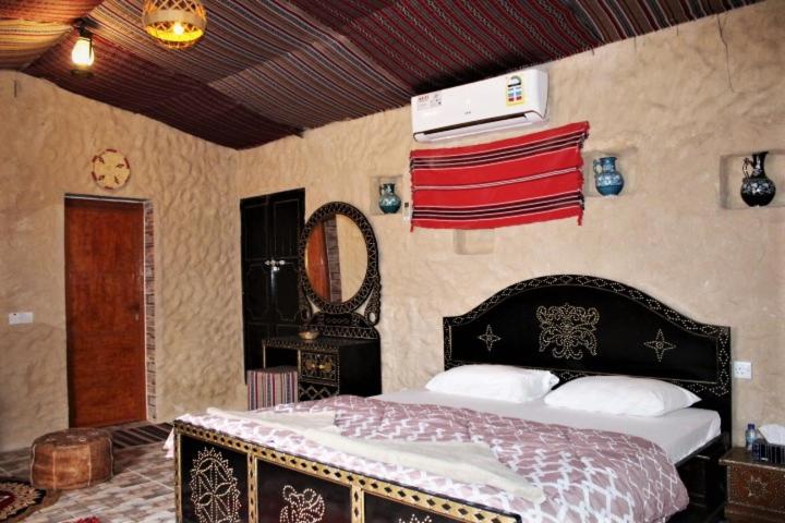 Un pat sau paturi într-o cameră la Al Reem Desert Camp