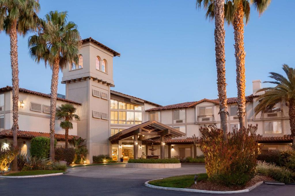 a building with palm trees in front of it at DoubleTree by Hilton Campbell - Pruneyard Plaza in Campbell