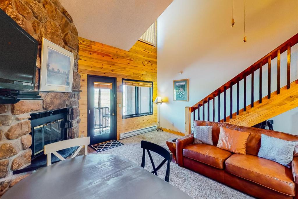 a living room with a couch and a fireplace at Silver Lodge A & B in Granby