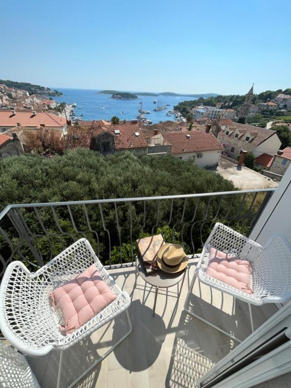 Duas cadeiras numa varanda com vista para o oceano em Apartments old town Hvar sea view em Hvar