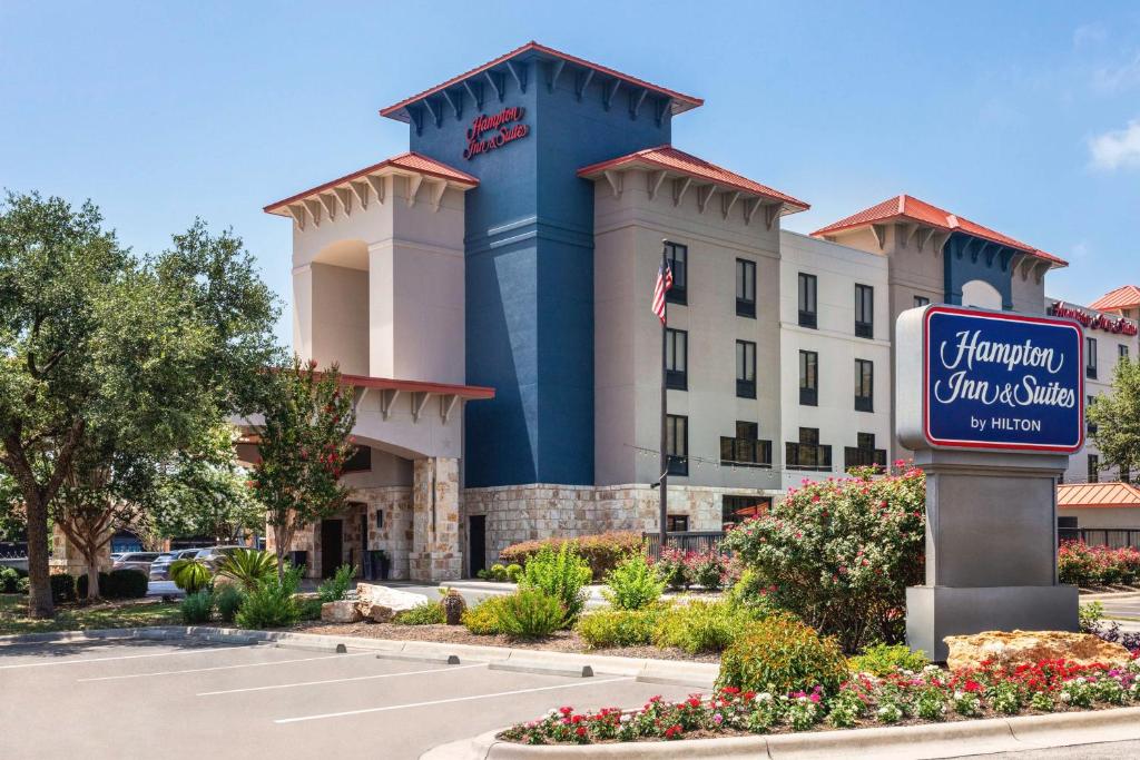 um hotel com uma placa em frente a um edifício em Hampton Inn & Suites San Marcos em San Marcos