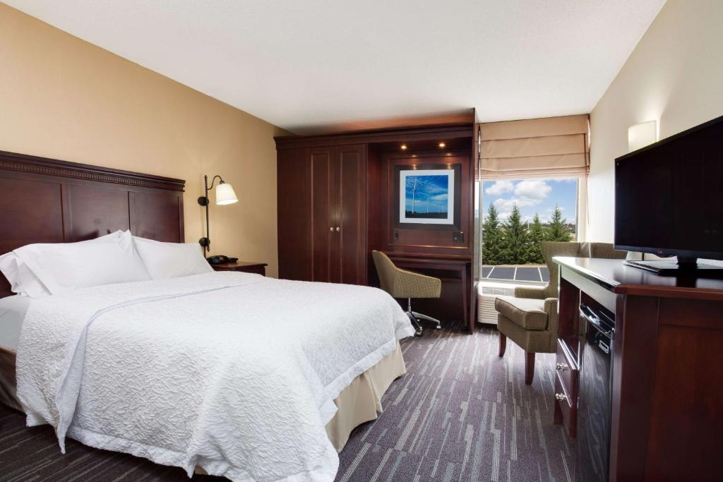 a hotel room with a bed and a flat screen tv at Hampton Inn Somerset in Somerset