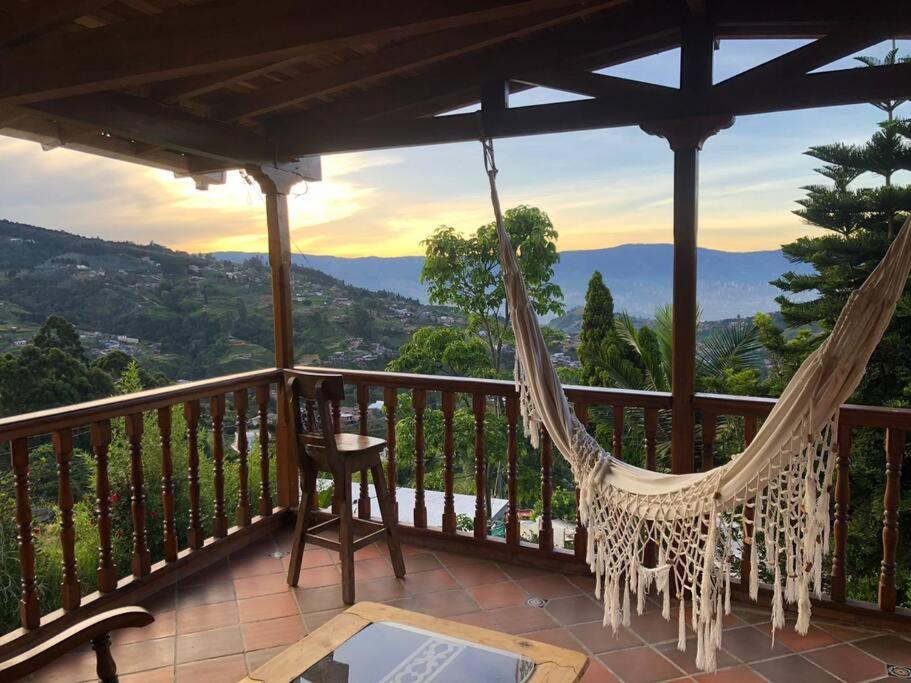 a hammock on a porch with a view of the mountains at Hermosa casa finca en Medellín con jacuzzi ! in Medellín