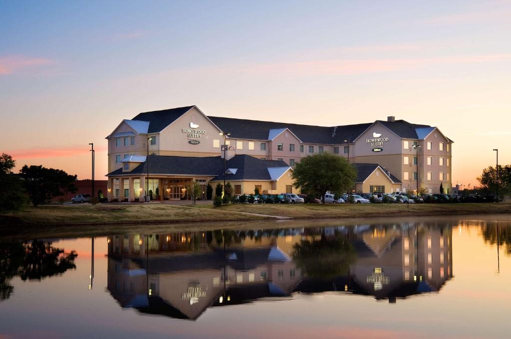 a large building sitting next to a body of water at Homewood Suites Wichita Falls in Wichita Falls