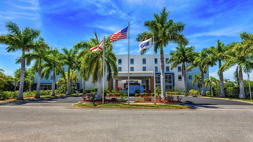 サラソタにあるHampton Inn & Suites Sarasota / Bradenton - Airportのヤシの木が目の前に広がる白い建物