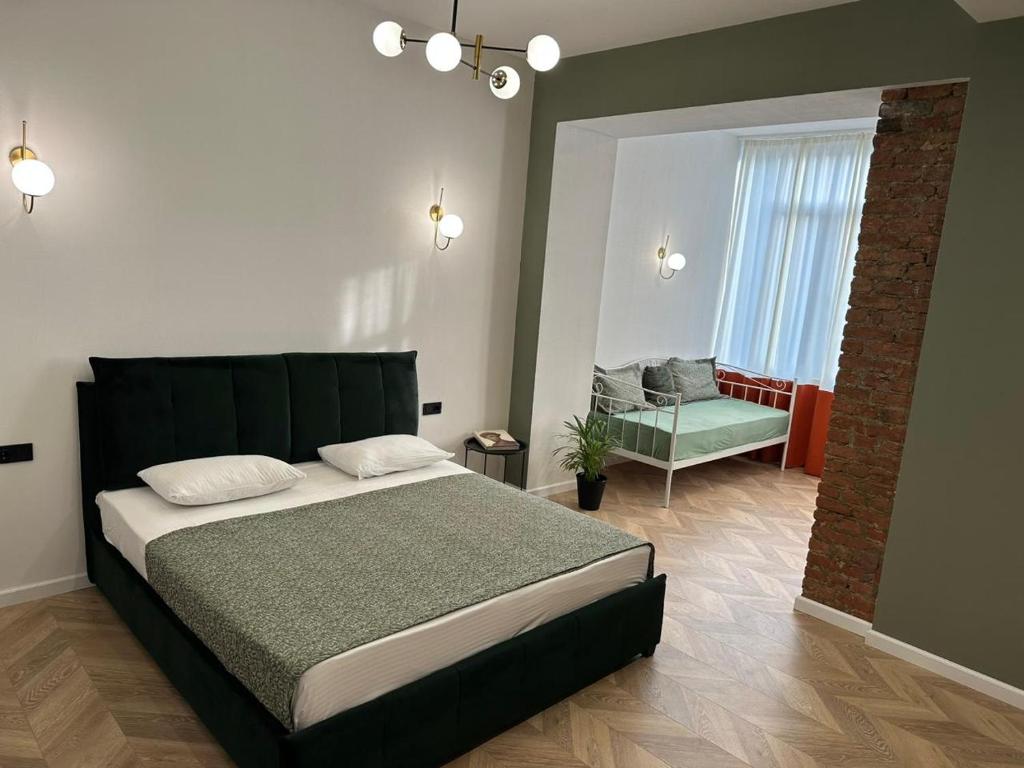 a bedroom with a large bed and a chair at Aparthotel Old Avenue in Tbilisi City