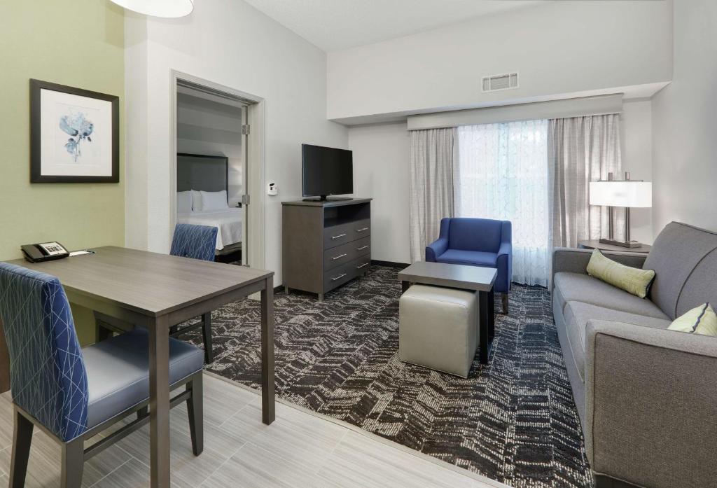 Homewood Suites by Hilton Saint Louis-Chesterfield في تشيسترفيلد: غرفة في الفندق مع أريكة وطاولة وسرير