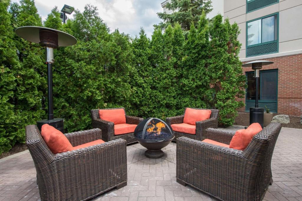 un patio con sillas de mimbre y una hoguera en Hilton Garden Inn Fishkill, en Fishkill