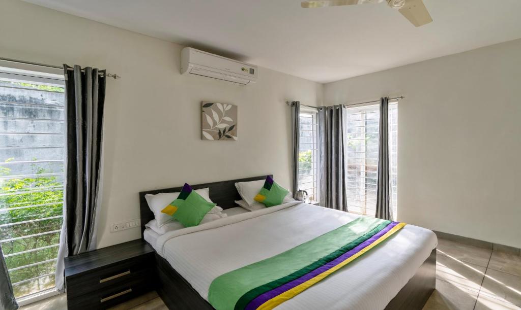 1 dormitorio con cama grande y ventana grande en Treebo Trend Midvalley Residence en Yelagiri